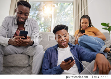 Phone, communication and african friends on social media for browsing while sitting on a living room sofa. App, contact and internet with a group of black people using mobile technology in a home Phone, communication and african friends on social media for browsing while sitting on a living room sofa. App, contact and internet with a group of black people using mobile technology in a home 136314368