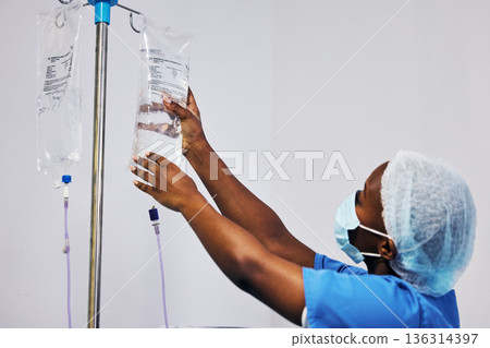 Hospital, nurse with face mask and black woman with iv drip medicine, fluid infusion or liquid injection bag. Nursing, doctor or surgeon monitoring intravenous medication, .anesthesia or healthcare Hospital, nurse with face mask and black woman with iv drip medicine, fluid infusion or liquid injection bag. Nursing, doctor or surgeon monitoring intravenous medication, .anesthesia or healthcare 136314397