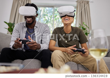 Funny couple, vr and gaming on sofa in home living room, happy and laughing together. Virtual reality, couch and African man and woman play 3d game, metaverse and esports with futuristic technology. 136314419