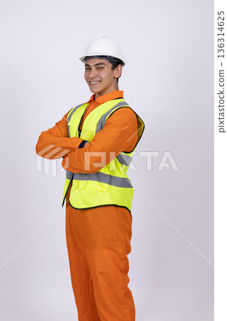 Confident construction worker in reflective vest crossing arms 136314625