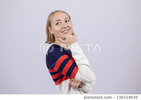 Thoughtful woman in striped sweater looking away Thoughtful woman in striped sweater looking away 136314630