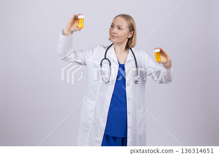 Doctor in white coat holding pill bottle and tablet Doctor in white coat holding pill bottle and tablet 136314651