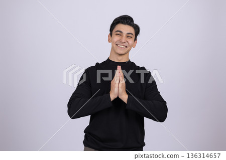 Young man in black turtleneck holding hands together Young man in black turtleneck holding hands together 136314657