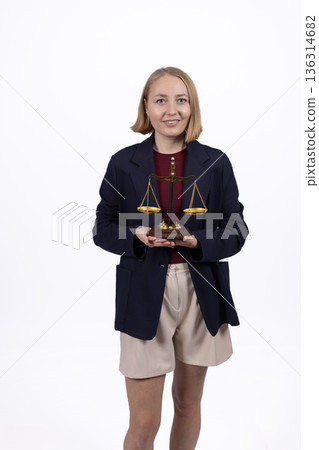 Young businesswoman in blazer holding justice scales Young businesswoman in blazer holding justice scales 136314682