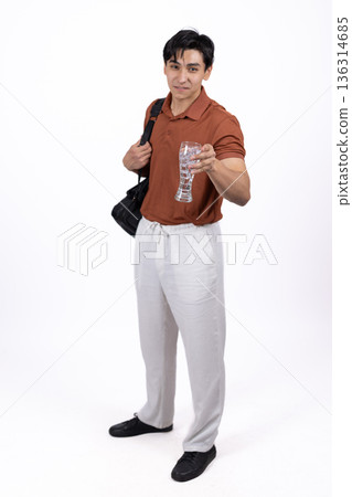 Young man in orange polo shirt and white trousers 136314685