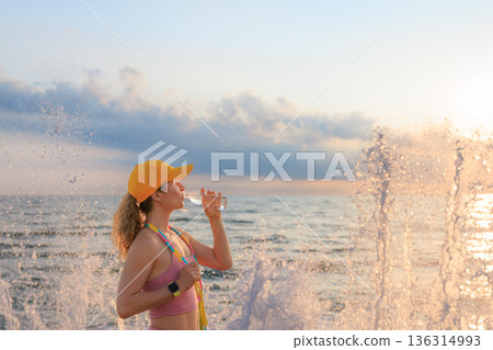 Fit woman jumping rope at the beach during summer vacation 136314993