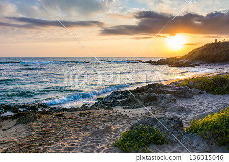 landscape of black sea sandy beach at sunrise. golden sand and rocks on the coast of bulgaria. beautiful view with sun above horizon. european summer vacation season and leisure concept landscape of black sea sandy beach at sunrise. golden sand and rocks on the coast of bulgaria. beautiful view with sun above horizon. european summer vacation season and leisure concept 136315046