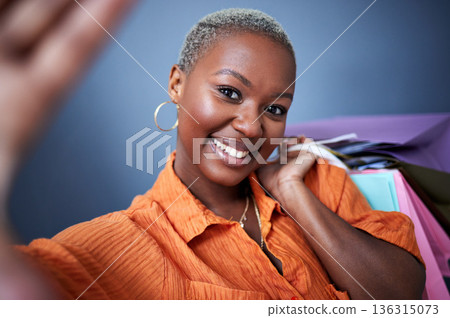 Selfie, smile and black woman with shopping, bags or fun sale in studio on grey background in boutique. Portrait, happy and African lady influencer with profile picture, blog or post with discount Selfie, smile and black woman with shopping, bags or fun sale in studio on grey background in boutique. Portrait, happy and African lady influencer with profile picture, blog or post with discount 136315073
