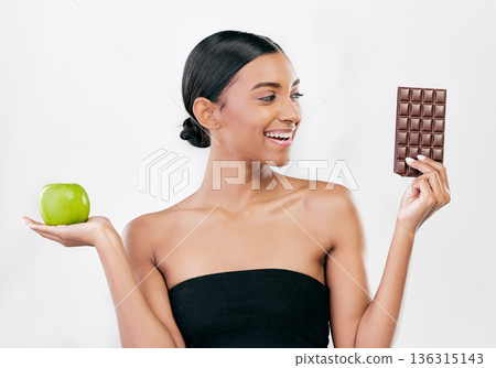 Apple, chocolate and woman with healthy food choice or offer isolated on studio, white background for sugar and diet. Dessert, green fruit and young person with detox, vegan or lose weight decision Apple, chocolate and woman with healthy food choice or offer isolated on studio, white background for sugar and diet. Dessert, green fruit and young person with detox, vegan or lose weight decision 136315143