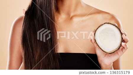 Closeup, woman or coconut of hair, beauty or cosmetic treatment for natural growth, sustainable cosmetics or studio background. Female model, tropical fruits or vegan dermatology of healthy hairstyle 136315179