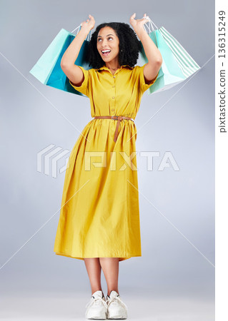 Excited, celebration and woman with shopping bag for fashion in studio isolated on a white background. Smile, sales and African customer with gift, discount deal or clothes from store, retail or mall Excited, celebration and woman with shopping bag for fashion in studio isolated on a white background. Smile, sales and African customer with gift, discount deal or clothes from store, retail or mall 136315249
