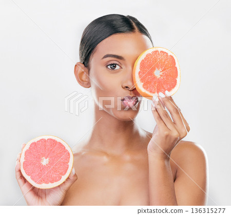 Indian woman, portrait with grapefruit for beauty, skincare and natural cosmetics for healthy glow, citrus or vitamin c. Face, emoji and skin care with fruit for wellness, health and white background 136315277
