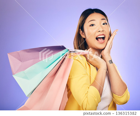Asian woman, surprise and shopping bag with retail and fashion, commercial and sale on purple background. Wow for discount at boutique, happy female customer and market with store promotion in studio Asian woman, surprise and shopping bag with retail and fashion, commercial and sale on purple background. Wow for discount at boutique, happy female customer and market with store promotion in studio 136315382