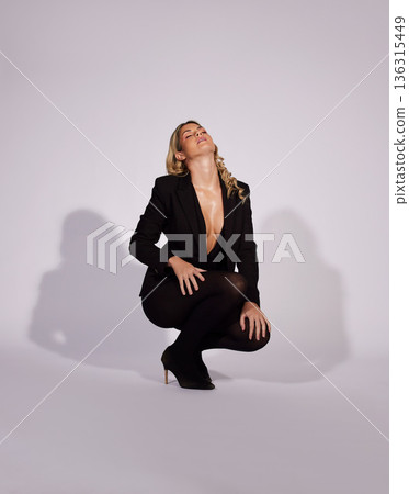 Fashion, suit and woman with confidence in studio isolated on a white background mockup space. Style, aesthetic and female model with formal clothes, classy makeup cosmetics and kneel with sexy pose 136315449