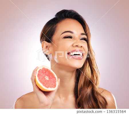 Happy woman, grapefruit and smile for vitamin C in skincare against a studio background. Face of female person or model with organic fruit for natural nutrition, diet or healthy wellness in happiness Happy woman, grapefruit and smile for vitamin C in skincare against a studio background. Face of female person or model with organic fruit for natural nutrition, diet or healthy wellness in happiness 136315564