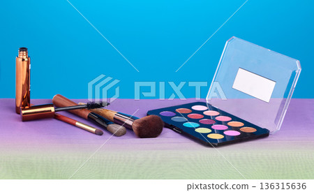 Makeup, product and palette for color in studio, brush and cosmetics for beauty, mock up and blue background. Powder, mascara and skincare with transformation, change and eyeshadow for aesthetic 136315636