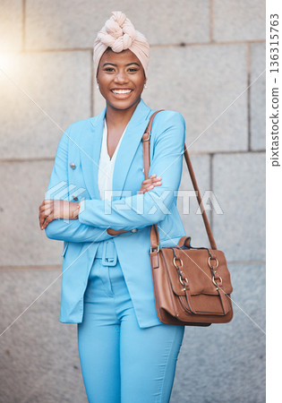 Confidence, success and portrait of businesswoman with crossed arms in the city by her office building. Smile, happy and professional young African female lawyer with a briefcase in an urban town. Confidence, success and portrait of businesswoman with crossed arms in the city by her office building. Smile, happy and professional young African female lawyer with a briefcase in an urban town. 136315763