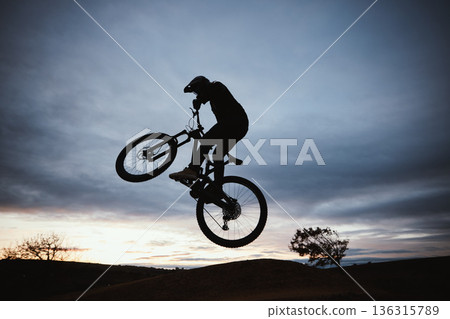Motorcycle, sunset and jump with sport with sky or action with training in outdoor for race or risk. Adventure, silhouette and dirt bike with speed in nature with freedom or power in desert on hill. 136315789