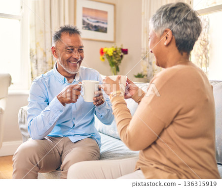 Coffee, smile and a senior couple on a sofa in the home living room to relax while bonding in conversation. Love, retirement or marriage with a mature man and woman talking while drinking a beverage 136315919