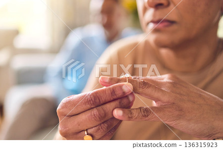 Senior couple, hands and ring in divorce, fight or conflict from disagreement or argument on sofa at home. Elderly man and woman in depression, infertility or cheating and toxic marriage in the house Senior couple, hands and ring in divorce, fight or conflict from disagreement or argument on sofa at home. Elderly man and woman in depression, infertility or cheating and toxic marriage in the house 136315923