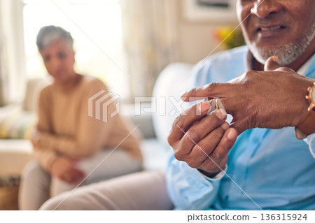 Senior man, hands and ring in divorce, fight or conflict from disagreement or argument on sofa at home. Elderly couple in depression, infertility or cheating, mistake and toxic marriage in the house Senior man, hands and ring in divorce, fight or conflict from disagreement or argument on sofa at home. Elderly couple in depression, infertility or cheating, mistake and toxic marriage in the house 136315924