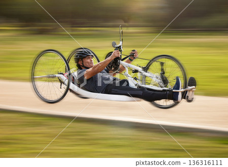 Cycling, fitness and fast with man and handcycle in nature for training, sports and challenge. Exercise, workout and motion blur with person with a disability in park for cardio and health on road Cycling, fitness and fast with man and handcycle in nature for training, sports and challenge. Exercise, workout and motion blur with person with a disability in park for cardio and health on road 136316111