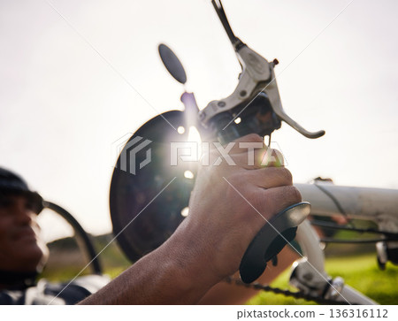 Brakes, cycling and hands on a bicycle for a person with a disability to exercise, cycle and fitness training in the park. Braking, hand on pedal or handlebars to stop, slow or control speed on bike 136316112
