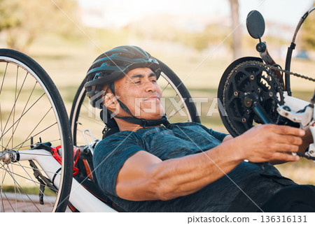 Cycling, fitness and man with disability in race, training for competition with smile, motivation and exercise on bike. Sports, workout and person on handcycle bicycle on outdoor track for challenge. Cycling, fitness and man with disability in race, training for competition with smile, motivation and exercise on bike. Sports, workout and person on handcycle bicycle on outdoor track for challenge. 136316131