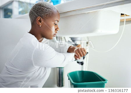 Plumbing, leak and time with a black woman in the bathroom of her home waiting for repair assistance. Sink, emergency and watch with a young female homeowner in her house to stop water using a bucket Plumbing, leak and time with a black woman in the bathroom of her home waiting for repair assistance. Sink, emergency and watch with a young female homeowner in her house to stop water using a bucket 136316177