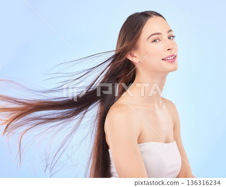 Portrait, hair and beauty with a model woman in studio on a blue background for shampoo or keratin treatment. Spa, salon or hairdresser with an attractive young female person posing for haircare 136316234