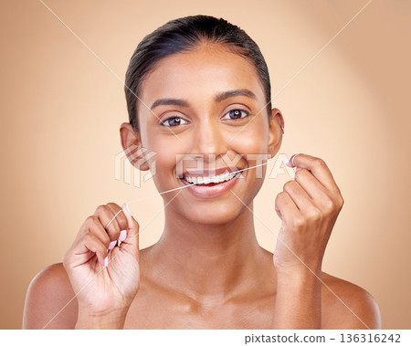 Woman, mouth and flossing in studio portrait with smile, cleaning or teeth whitening by brown background. Girl, model and happy for dentistry product, string or self care for tooth, beauty or health Woman, mouth and flossing in studio portrait with smile, cleaning or teeth whitening by brown background. Girl, model and happy for dentistry product, string or self care for tooth, beauty or health 136316242