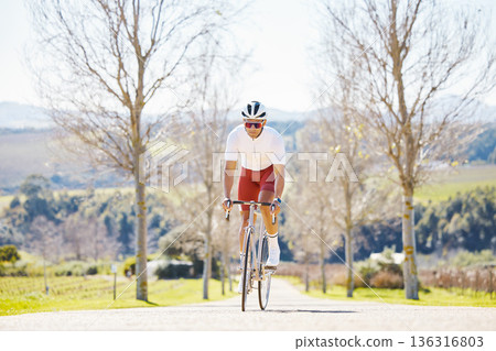 Sports, cycling and man on a bike in a park for fitness, training or morning cardio routine in nature. Bicycle, exercise and male cyclist riding on path for practice, freedom or performance challenge 136316803