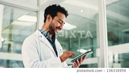 Man, doctor and smile with tablet in hospital for research, medical report and confirm surgery. Male surgeon, digital and browsing website for Telehealth, healthcare results and treatment information 136316950