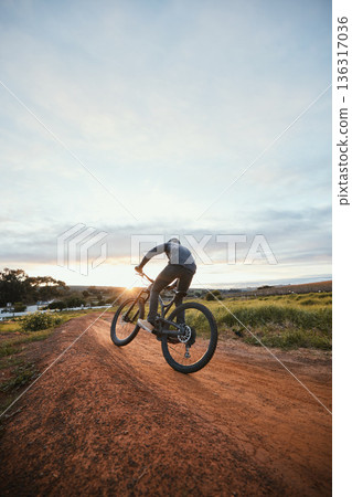 Sports, cycling and man on bicycle in countryside for training, workout and exercise in nature. Fitness, cyclist and person with mountain bike for adventure, freedom and ride on outdoor dirt road Sports, cycling and man on bicycle in countryside for training, workout and exercise in nature. Fitness, cyclist and person with mountain bike for adventure, freedom and ride on outdoor dirt road 136317036