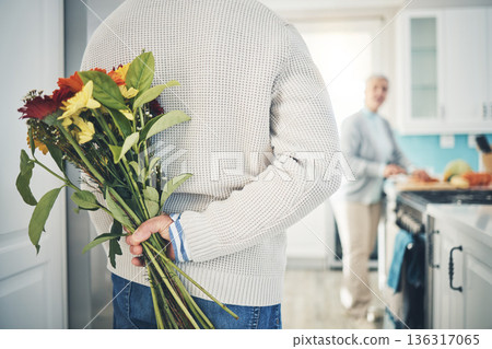 Senior, couple and flowers for love in home, kitchen or husband with bouquet of roses to surprise woman in happy marriage. Man, wife and back hiding gift, flower and romance together on anniversary Senior, couple and flowers for love in home, kitchen or husband with bouquet of roses to surprise woman in happy marriage. Man, wife and back hiding gift, flower and romance together on anniversary 136317065