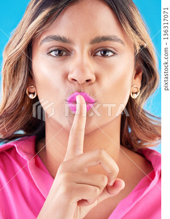 Woman with secret, finger to lips and pink lipstick in portrait, communication and sign language on blue background. Quiet gesture, privacy and gossip with silent emoji, female model and news 136317071