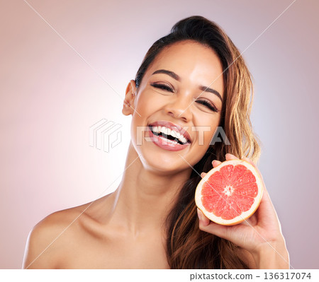 Happy woman, portrait and grapefruit for vitamin C in skincare against a studio background. Face of female person or model smile with organic fruit for natural nutrition, diet or healthy wellness 136317074
