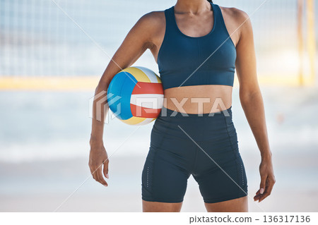 Woman, beach and volleyball for fitness, sports or workout in exercise or training by the ocean coast. Body of active female person with ball for volley practice by sea or healthy wellness in nature 136317136