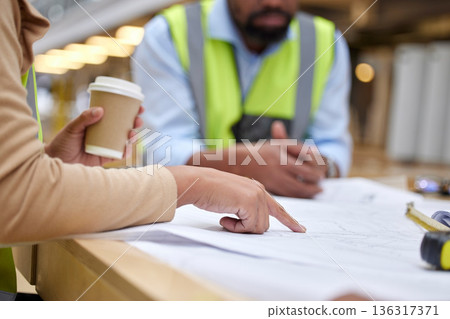 Construction, meeting and people with blueprint for planning with paperwork, illustration and document. Engineering design, teamwork and hands of workers on floorplan for building renovation on site 136317371