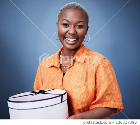 African woman, gift box and studio portrait with excited smile, birthday and blue background. African girl, happy and deal with present, package and fashion for celebration, winner and birthday party 136317380