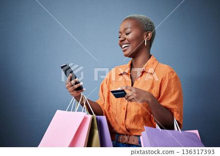 Bags, shopping and black woman with a credit card, cellphone and ecommerce on a grey studio background. Female person, shopper or model with smartphone, boutique items or payment with retail or smile Bags, shopping and black woman with a credit card, cellphone and ecommerce on a grey studio background. Female person, shopper or model with smartphone, boutique items or payment with retail or smile 136317393
