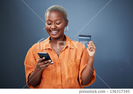 Smile, phone and credit card with a black woman online shopping in studio on a gray background. Mobile, ecommerce and finance payment with a happy young female shopper searching for a deal or sale Smile, phone and credit card with a black woman online shopping in studio on a gray background. Mobile, ecommerce and finance payment with a happy young female shopper searching for a deal or sale 136317395