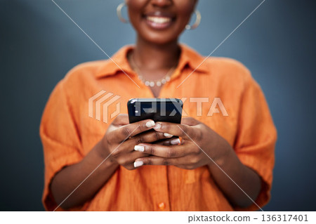 Typing, closeup and hands with a phone on a dark background for communication or social media. Smile, contact and a black woman with a mobile for an app or chat isolated on a studio backdrop for web Typing, closeup and hands with a phone on a dark background for communication or social media. Smile, contact and a black woman with a mobile for an app or chat isolated on a studio backdrop for web 136317401