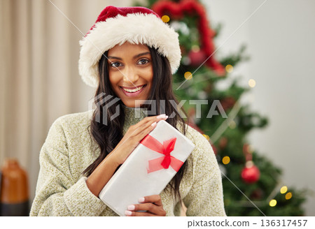 Woman, Christmas present and smile in portrait, celebrate holiday with happiness and wrapped box with ribbon. Special event, female person at home with gift giving and package, festive and xmas Woman, Christmas present and smile in portrait, celebrate holiday with happiness and wrapped box with ribbon. Special event, female person at home with gift giving and package, festive and xmas 136317457