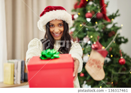 Woman giving gift, Christmas and smile in portrait, celebrate holiday with happiness and wrapped box with ribbon. Special event, female person at home with present and package, festive and xmas Woman giving gift, Christmas and smile in portrait, celebrate holiday with happiness and wrapped box with ribbon. Special event, female person at home with present and package, festive and xmas 136317461