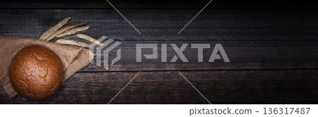Fresh round bread on black wooden board, view with copyspace. Long banner Fresh round bread on black wooden board, view with copyspace. Long banner 136317487