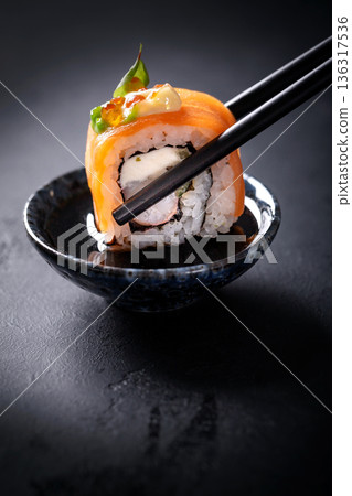 Japanese cuisine. Sushi rolls on a black platter 136317536