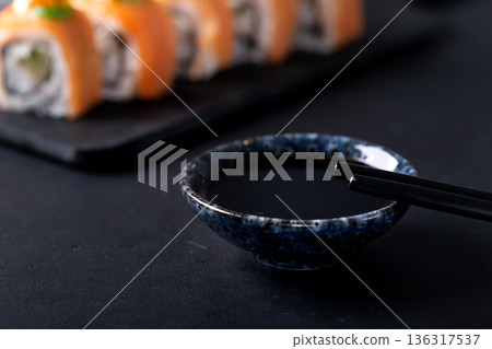 Japanese cuisine. Sushi rolls on a black platter Japanese cuisine. Sushi rolls on a black platter 136317537