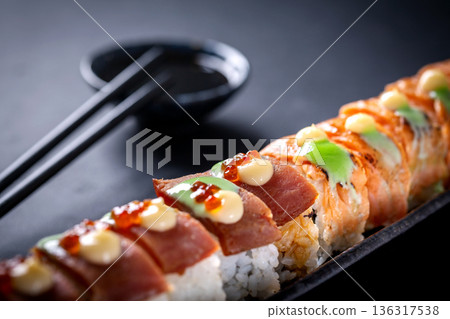Japanese cuisine. Sushi rolls on a black platter Japanese cuisine. Sushi rolls on a black platter 136317538