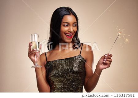 Happy woman, sparkler and celebration with party, Champagne and new year on studio background. Fireworks, alcohol drink in glass and holiday fun, luxury event and excited female person with sparks 136317591